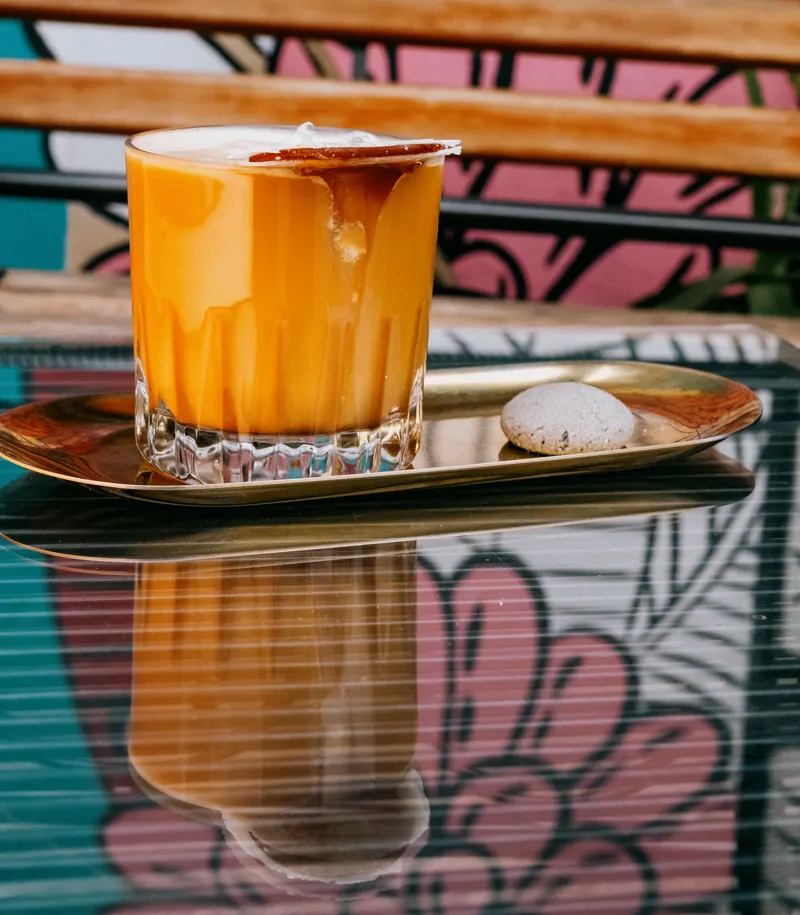 Bebida fría de café sobre charola dorada
