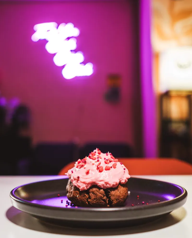 Postre con betún rosa bajo el neón